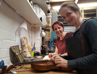 Chloe and Sophy at work setting up violins at The Violin Company