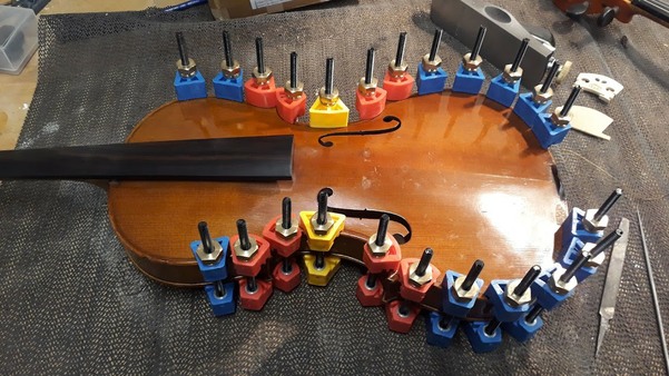 Violin on the bench with clamps after being reglued